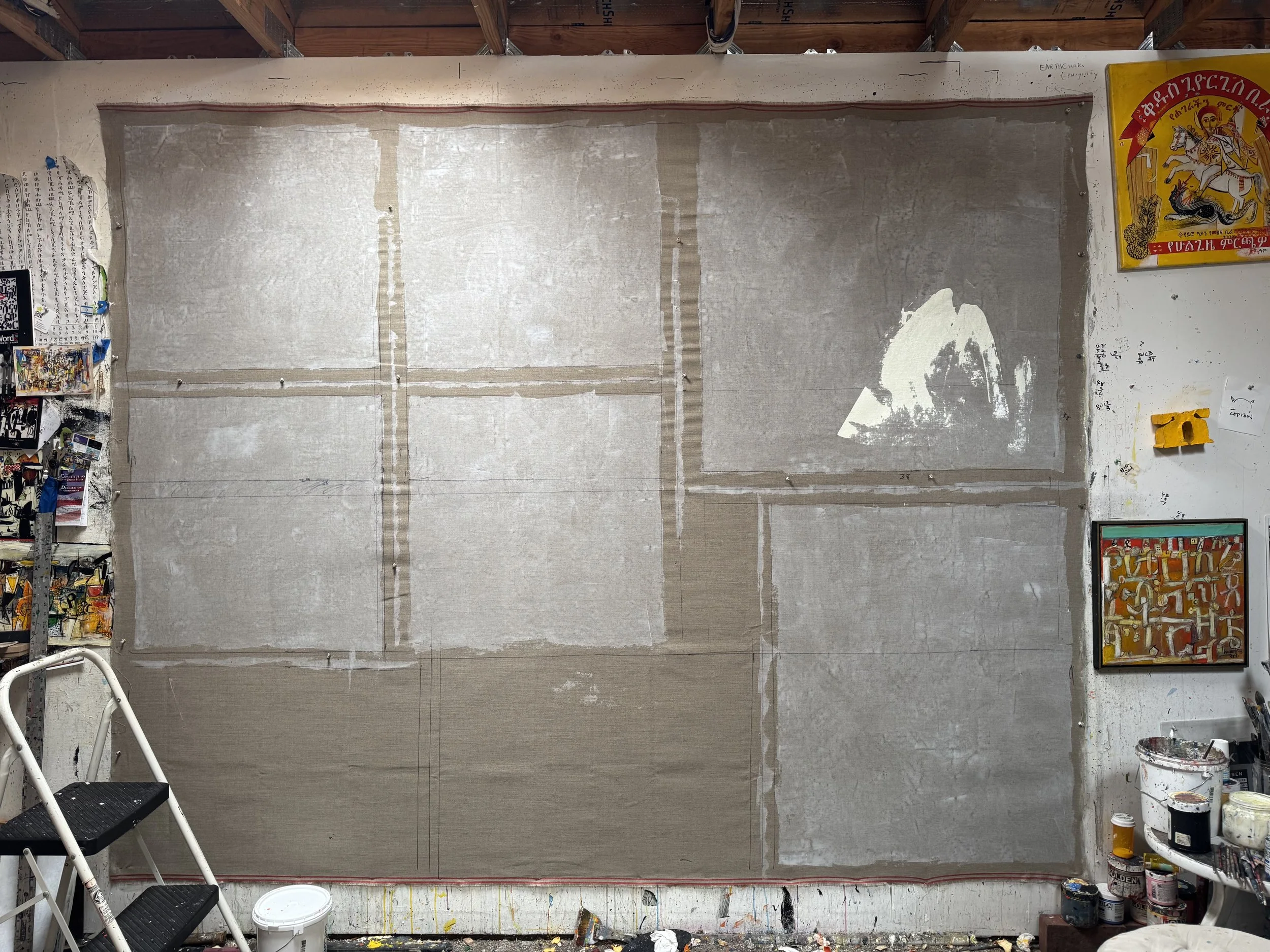 In his studio, Wosene prepares a new canvas, applying a thin layer of molding paste over raw linen, the first step in his painting process.