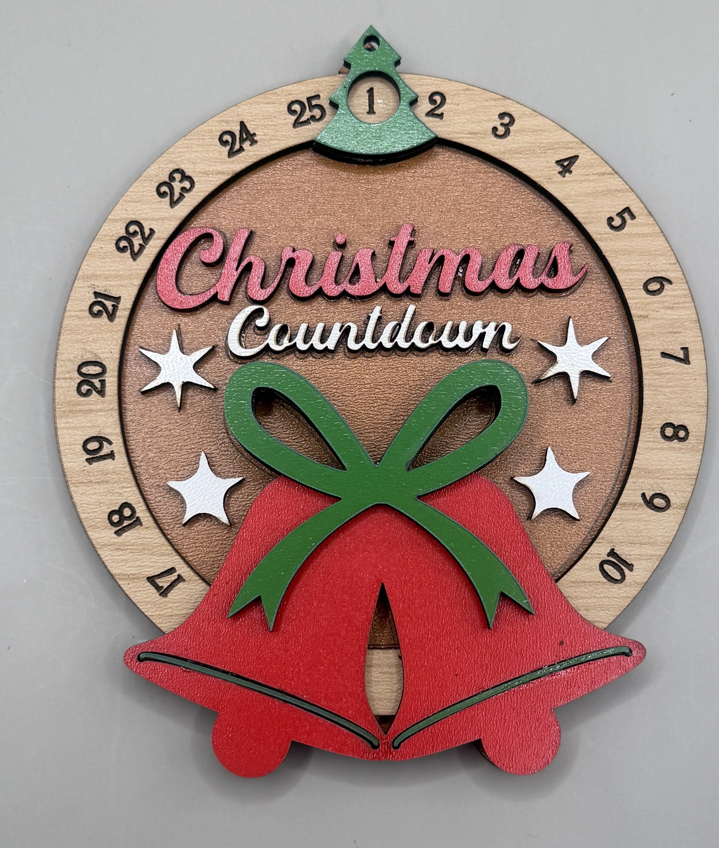 Hand-painted Christmas countdown ornament with red bells and rotating 1-25 dial, front view