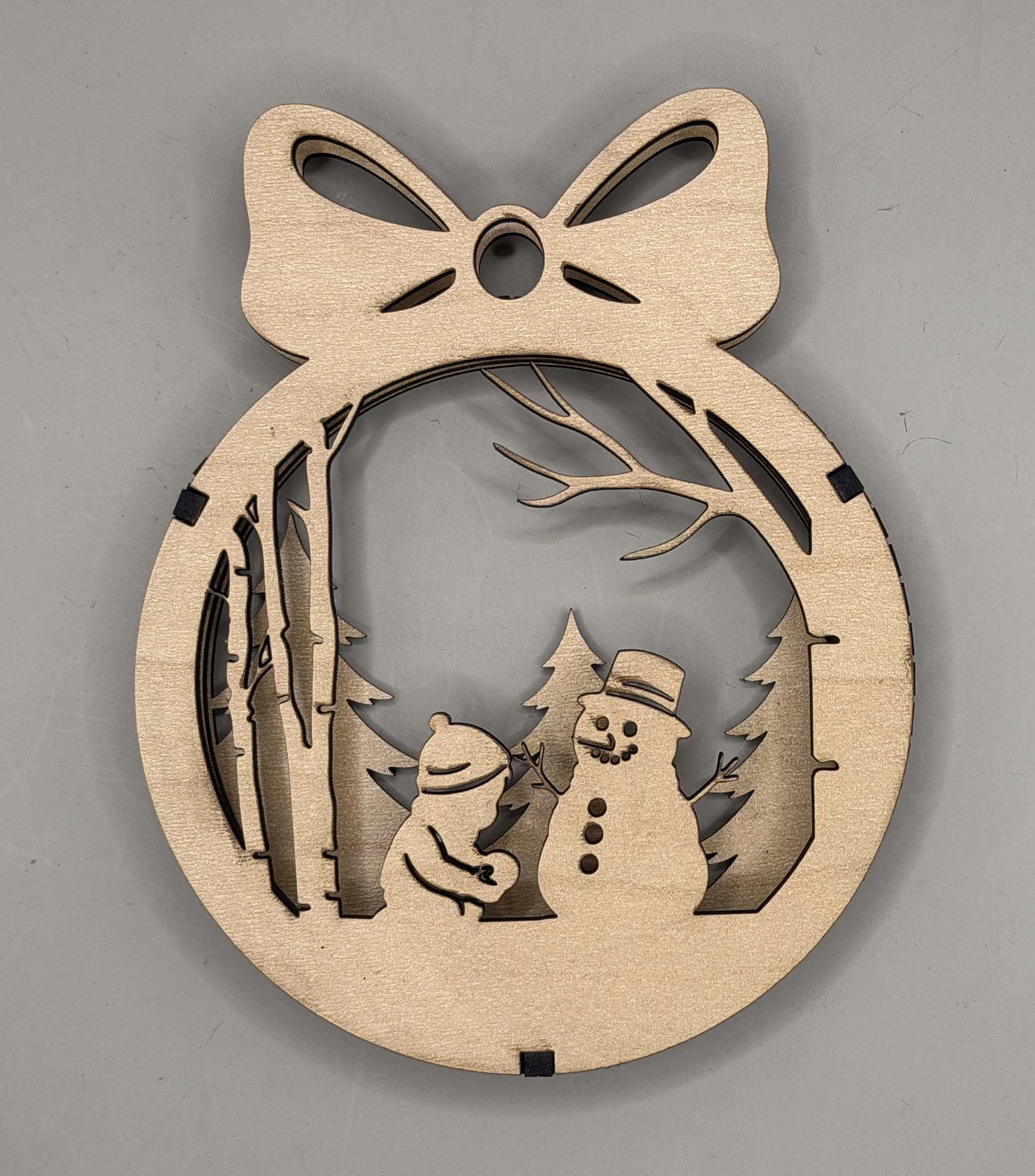 Child and snowman ornament from the Snow Day 3-pack, maple