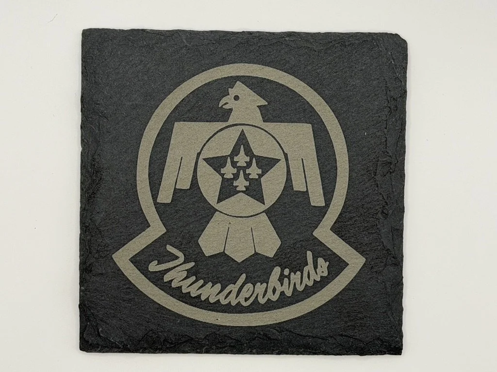 A rectangular black slate plaque with a beige graphic of a chicken and a star, and the word 'Thunderbirds' written below.