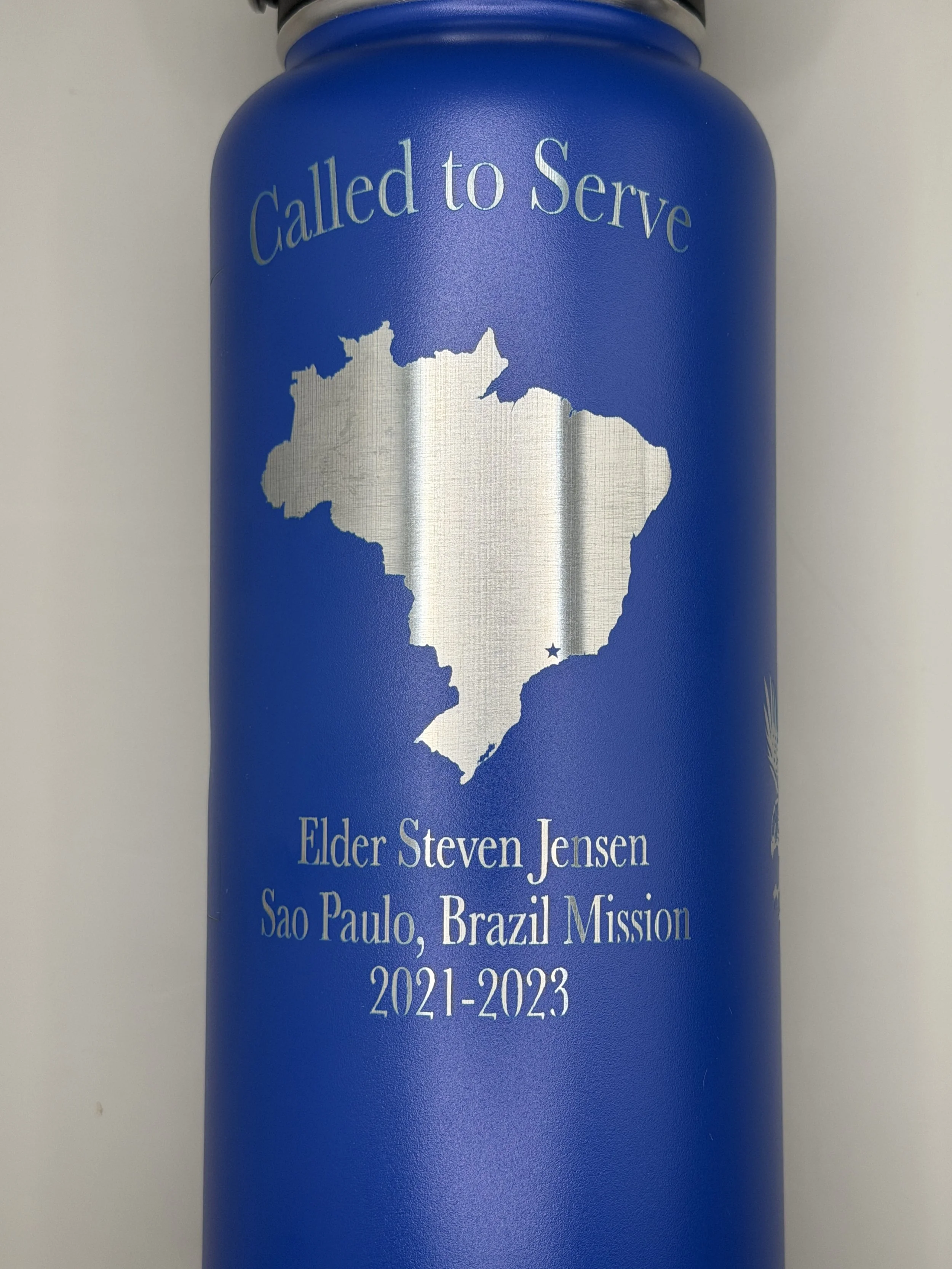 Blue bottle with silver map of Brazil, the words "Called to Serve" at the top, and text at the bottom reading "Elder Steven Jensen, Sao Paulo, Brazil Mission, 2021-2023."