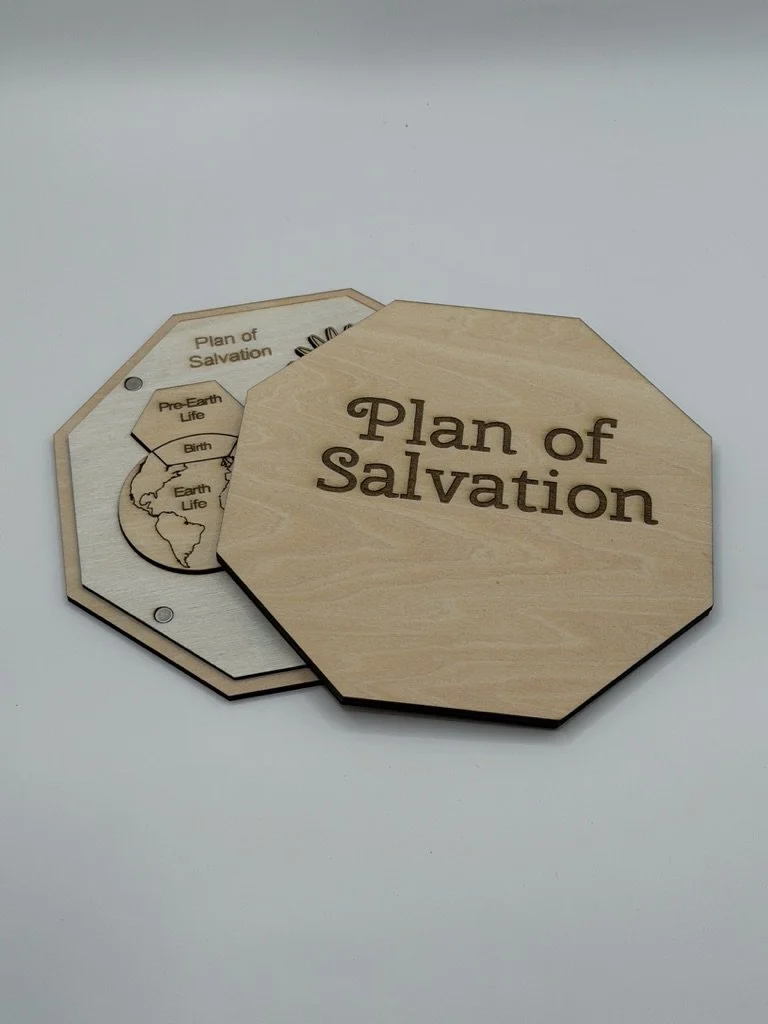 Wooden panels labeled 'Plan of Salvation' with an inset diagram showing the stages of Earth life, including Pre-Earth Life, Birth, and Earth Life.