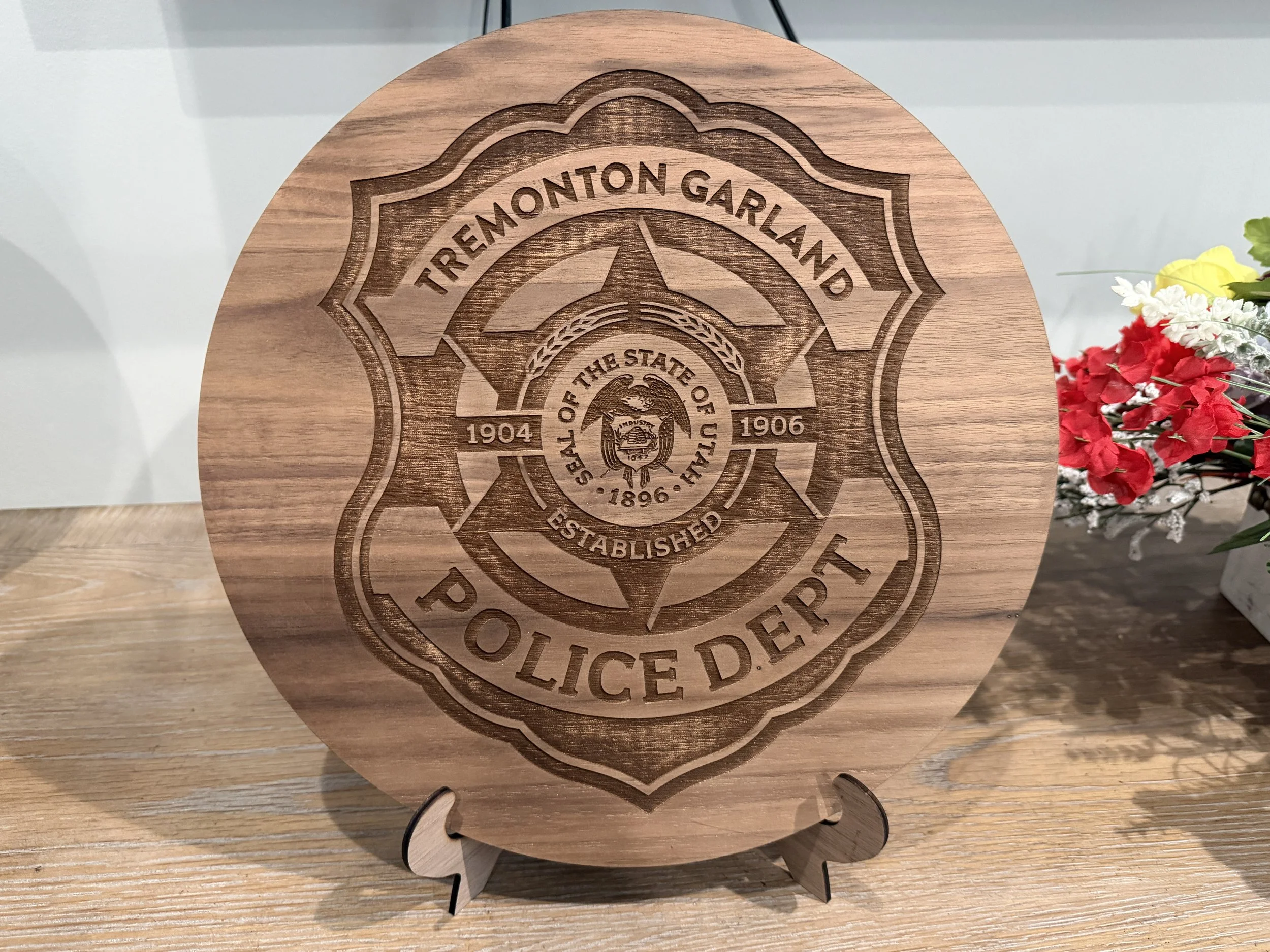 Wooden plaque engraved with the sheriff's badge of Treemont, Garland, established 1896, and years 1904 and 1906.