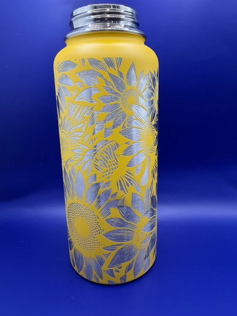 Yellow thermos with silver lid and sunflower pattern on blue background.