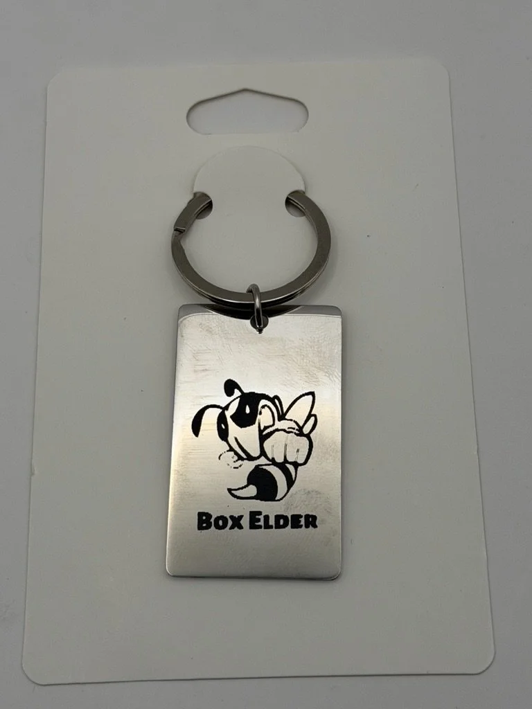 A silver keychain with a cartoon dog pointing and the text "Box Elder" on a white background.