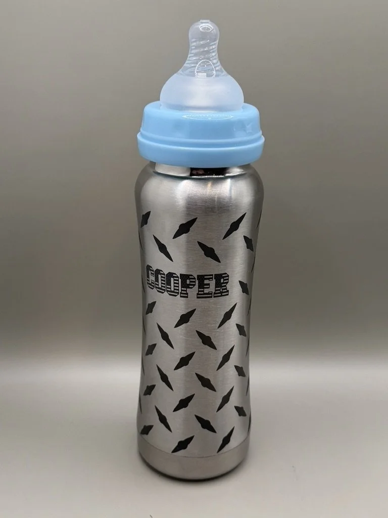 Stainless steel water bottle with a black fish scale pattern and the word 'GOBBER' printed on it. It has a blue and clear baby bottle nipple cap.