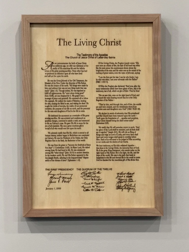 A framed document titled "The Living Christ" featuring the testimony of the apostles of The Church of Jesus Christ of Latter-day Saints, with signatures, dated January 1, 2000.