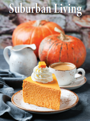 A slice of pumpkin pie with whipped cream on top, surrounded by pumpkins, a white teapot, and a teacup on a table with a gray cloth, outdoors.