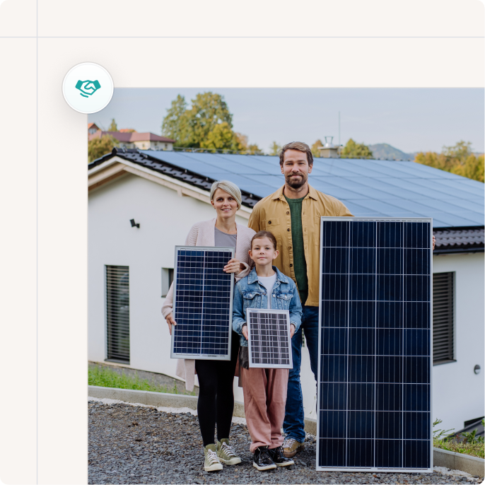 A family of three standing outside their house with solar panels, holding smaller solar panels.