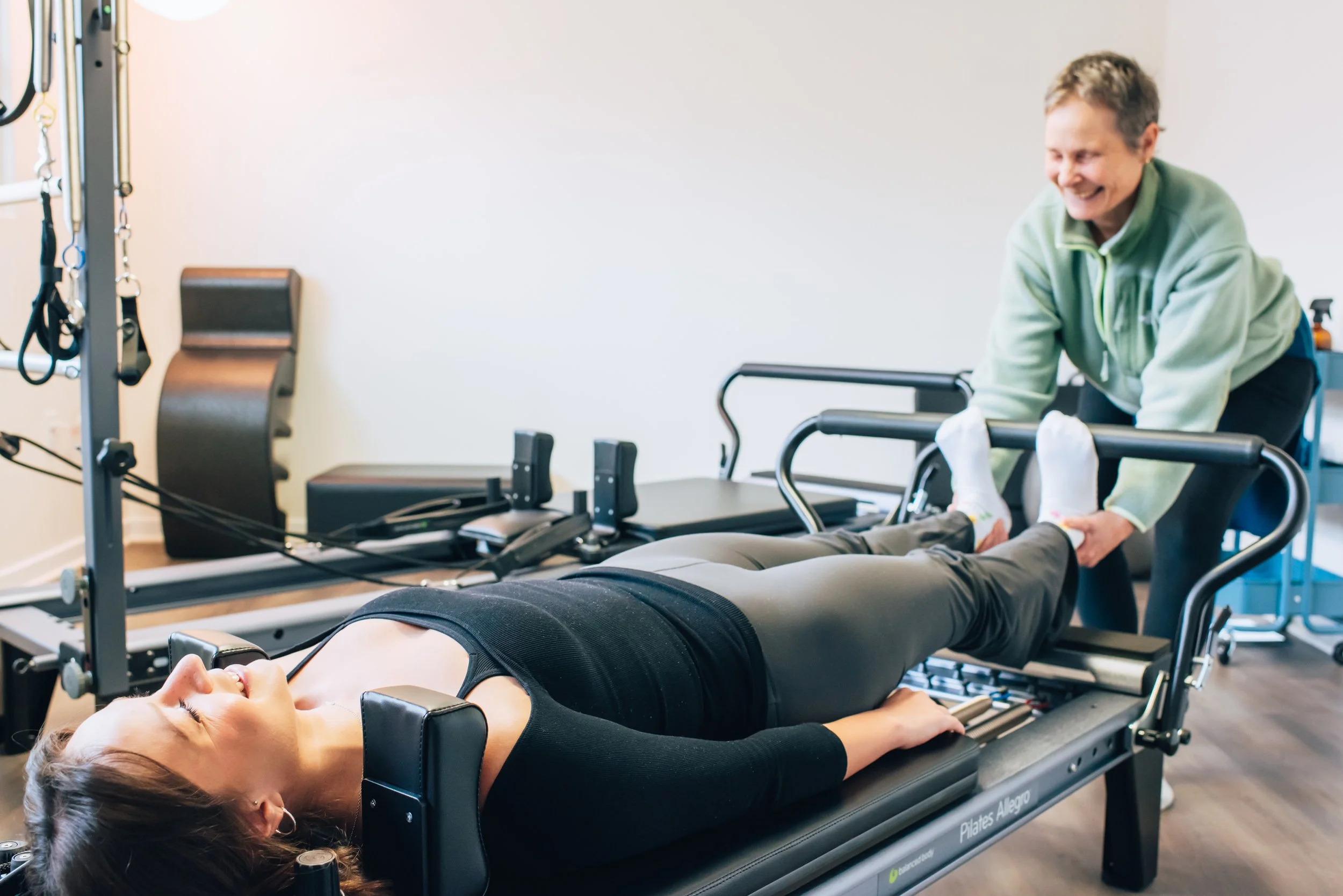 Jessica teaching a client to connect with their back body from their heels to the back of their head