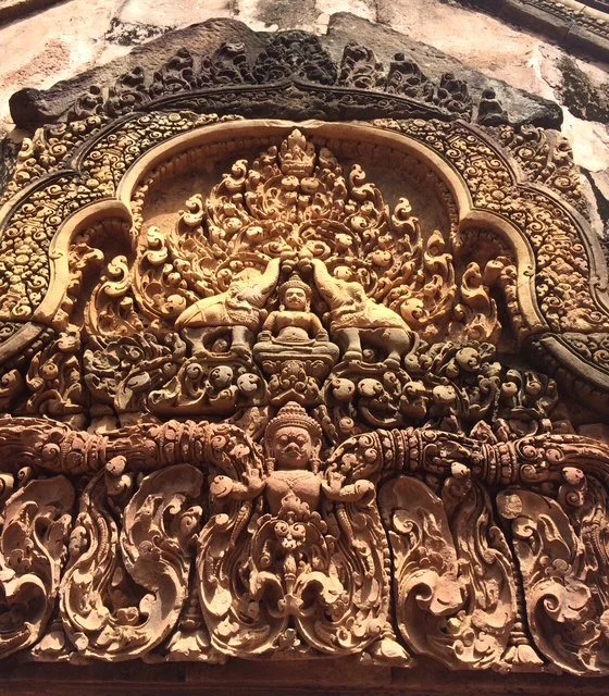 Detailed stone carving with intricate figures and decorative patterns, featuring a central deity figure surrounded by mythical and spiritual motifs. More Angkor Wat