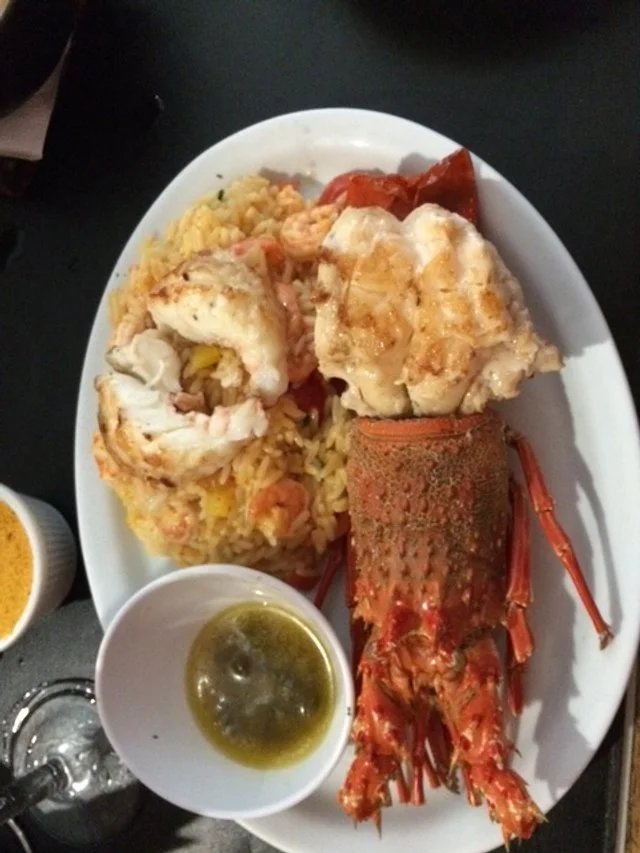 Seafood plate with rice, lobster tail, baked fish, and dipping sauce. Treat Yourself last day moment.