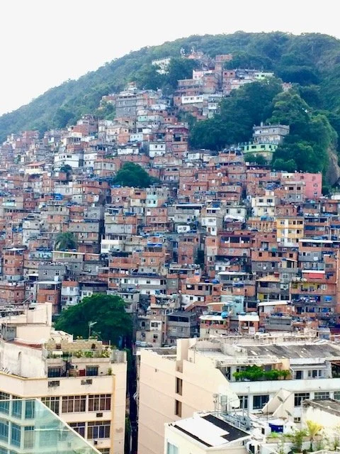 A densely populated hillside city with numerous colorful houses stacked on a steep slope.