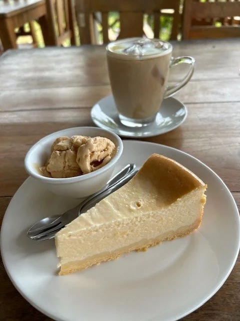Buffalo cheesecake on a white plate, accompanied a buffalo milk cappuccino.