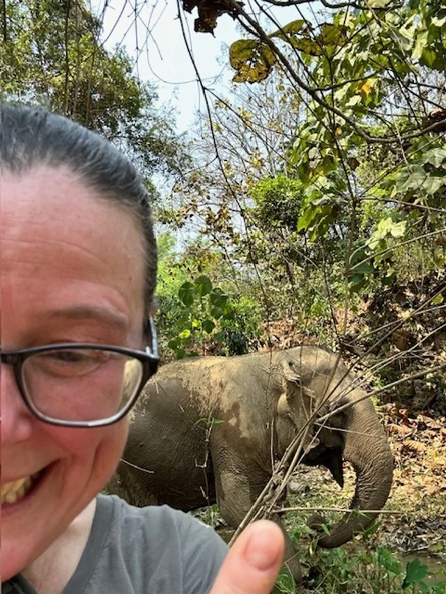 OBT taking a selfie with an elephant in a forested area. MandaLao Elephant Sanctuary