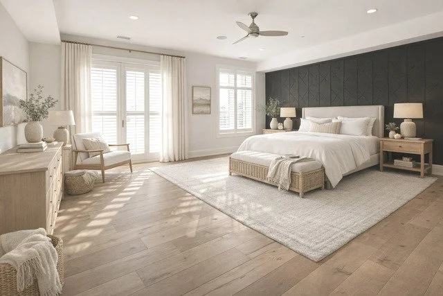 Bright, modern bedroom with white bedding, wooden furniture, and large windows with white shutters.