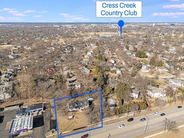 Aerial view of a residential neighborhood with a outlined property and a sign for Cress Creek Country Club in the background.