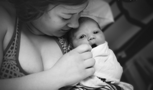 Mother holding and breastfeeding her baby in a cozy setting