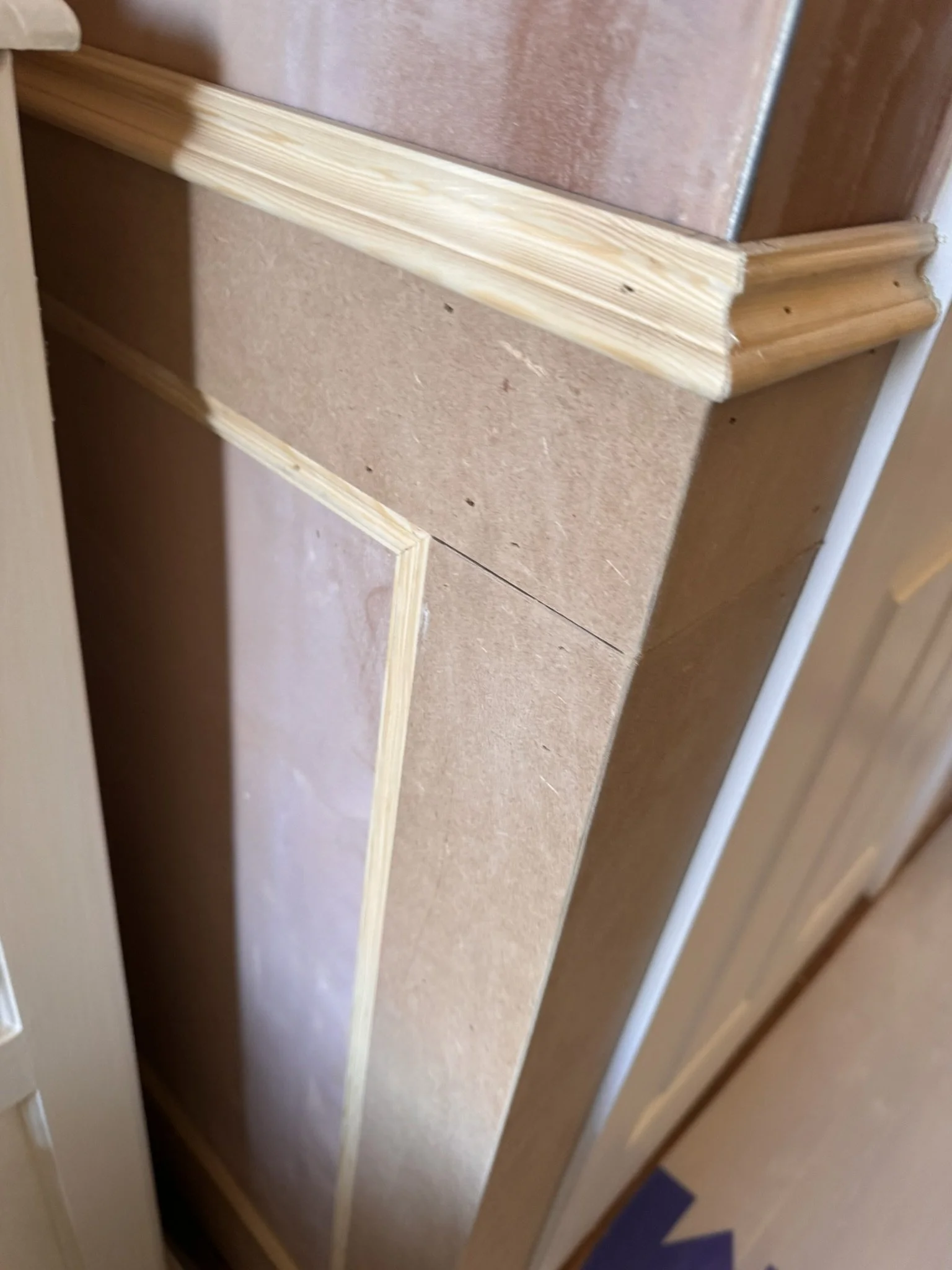 Close-up of a partially installed wooden and drywall door frame.