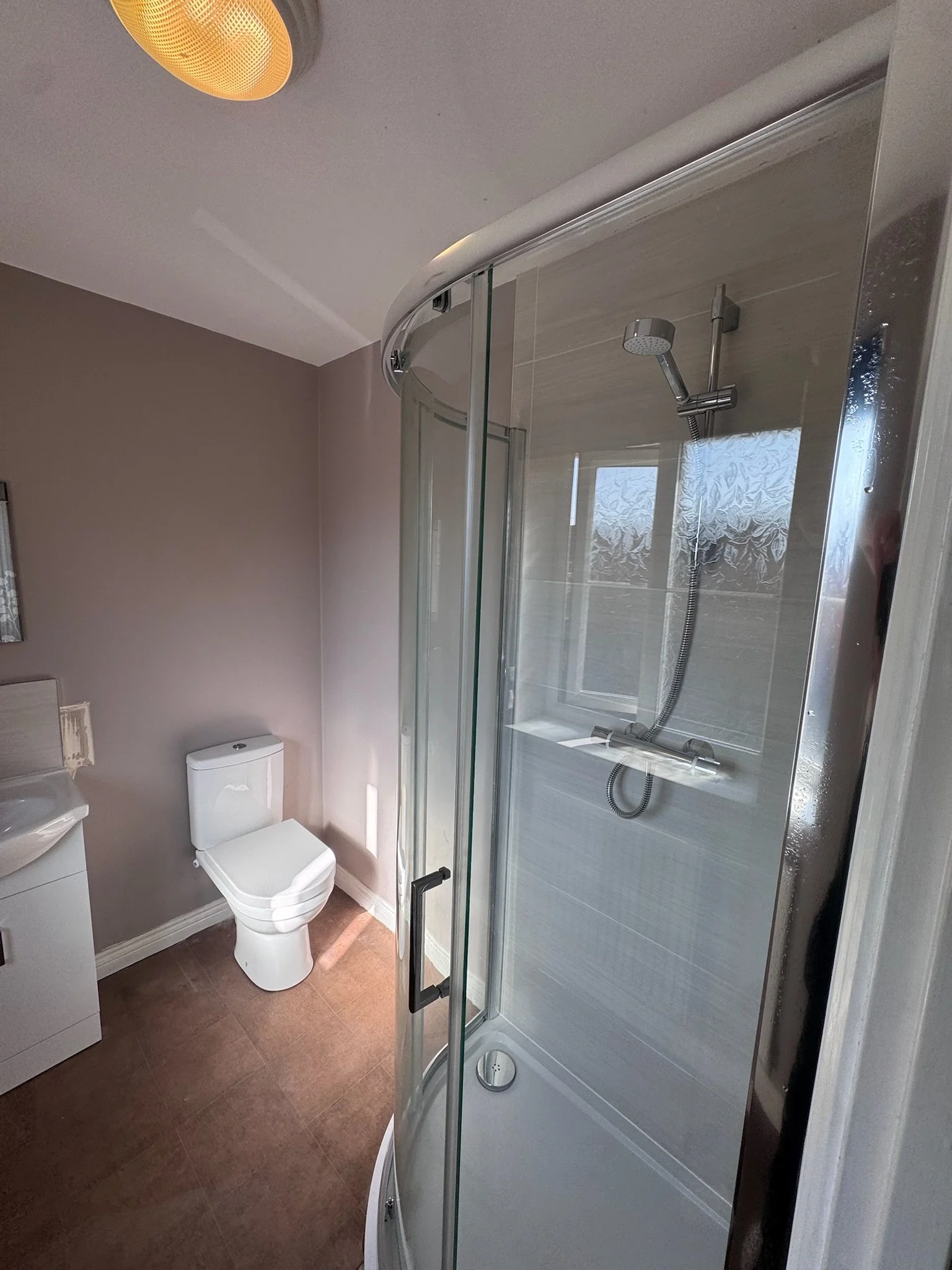 Bathroom with shower enclosure, toilet, and sink