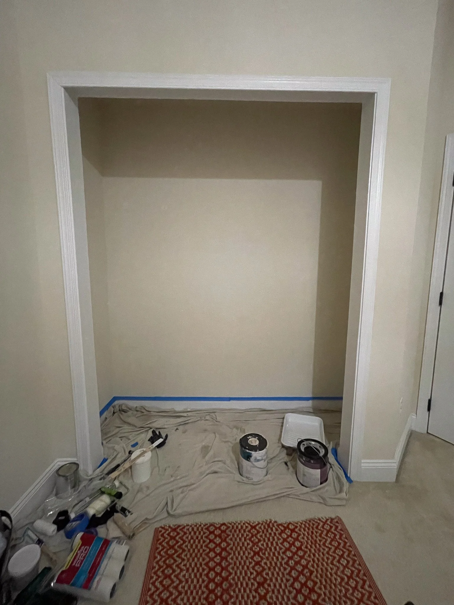 Empty closet with doors and hardware removed, creating a clean slate before installing an open shelving system
