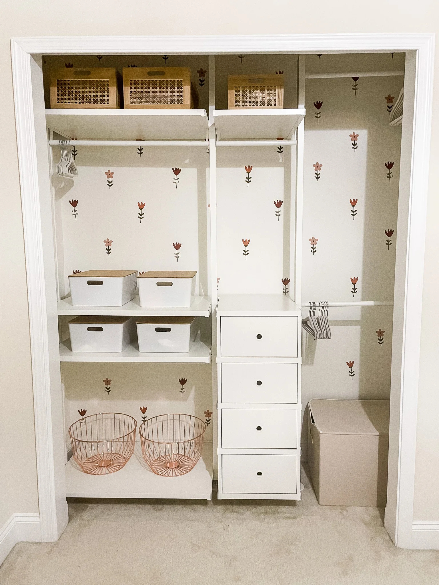 Open closet in progress featuring an IKEA shelving system and floral wall decals, combining functional storage with a cost-effective decorative accent.