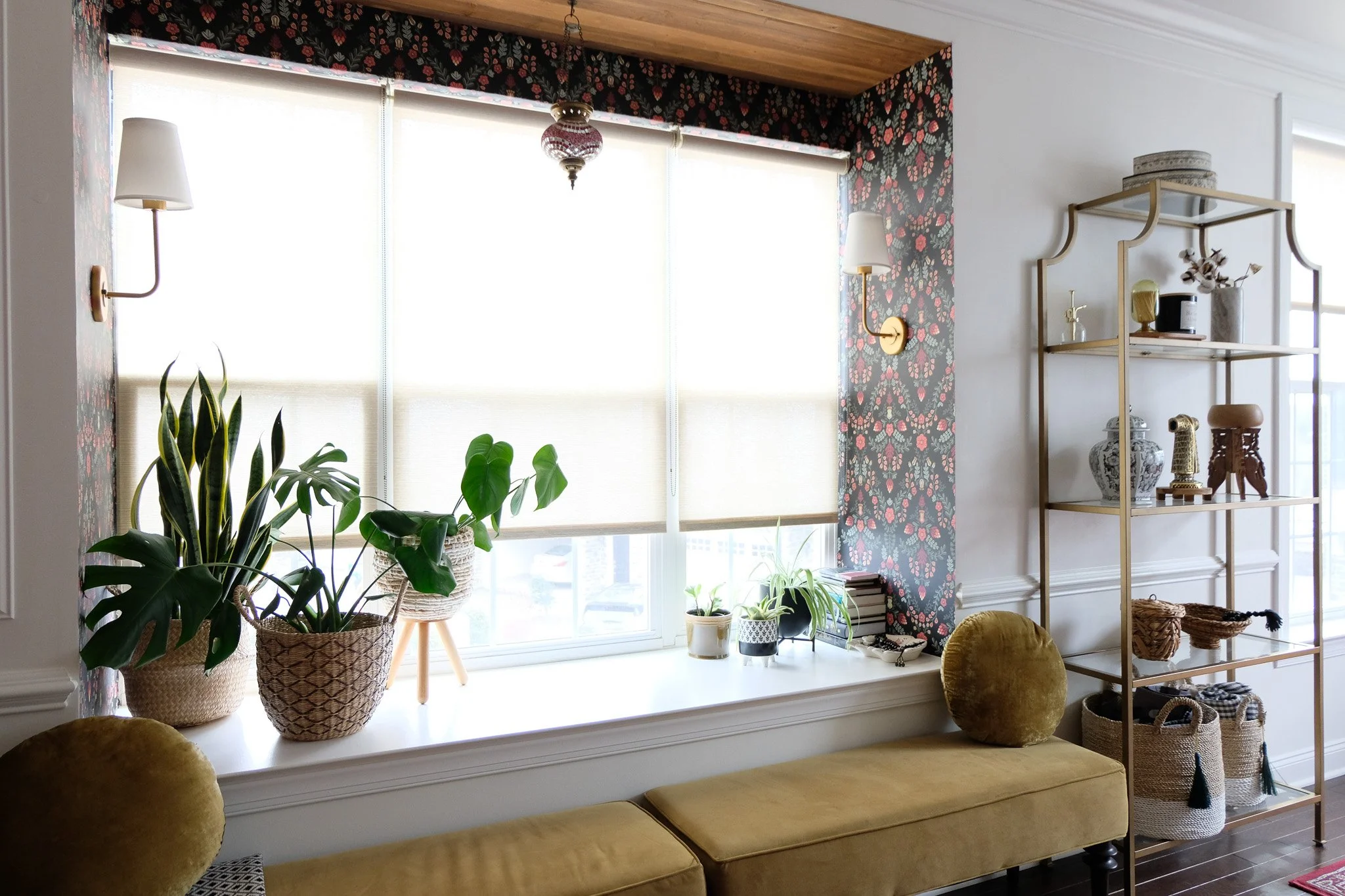 Bay window nook featuring patterned wallpaper installation, creating a warm, layered seating area with added visual interest and natural light.