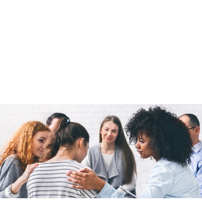 Group of diverse women having a serious discussion in a bright room with a white brick wall.