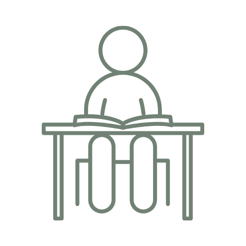 A simple line drawing of a person sitting at a desk, reading a book