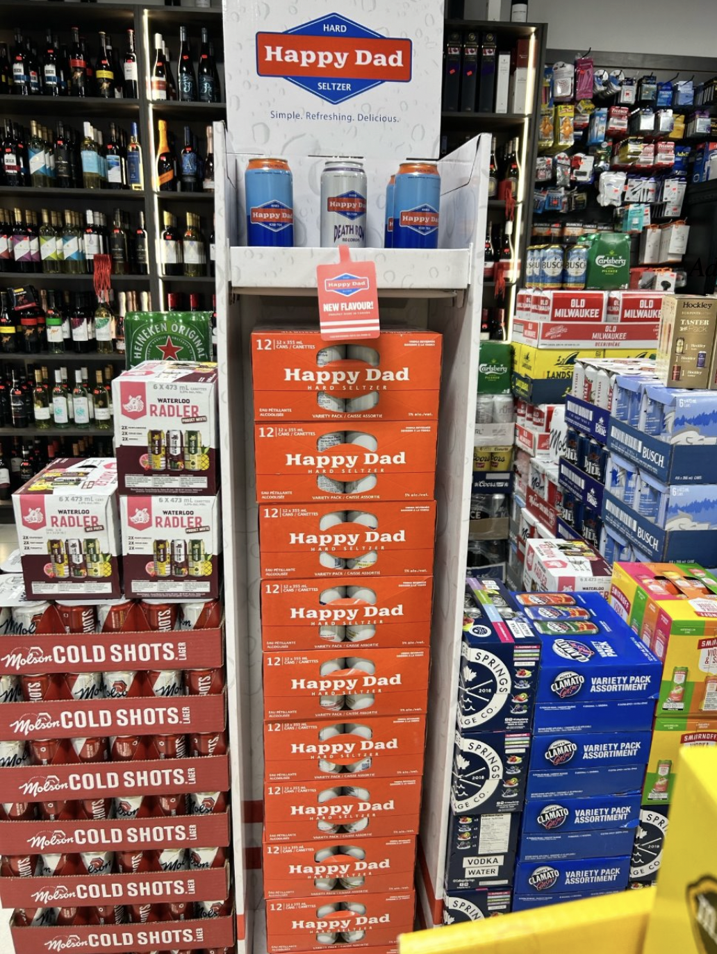 Stacked shelf display of Happy Dad seltzer variety packs in a convenience store.