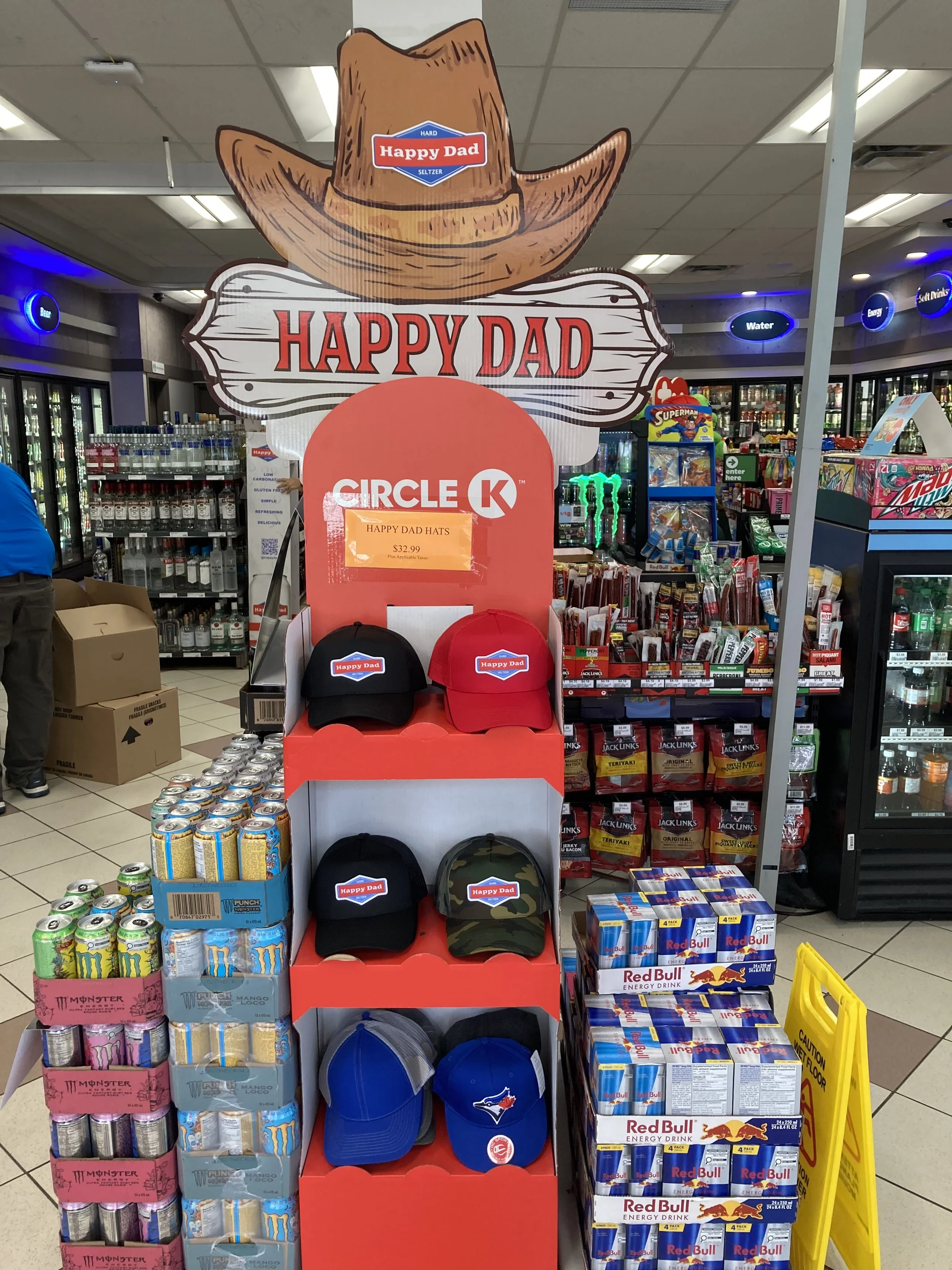 Store display of Happy Dad branded baseball hats in a convenience store.