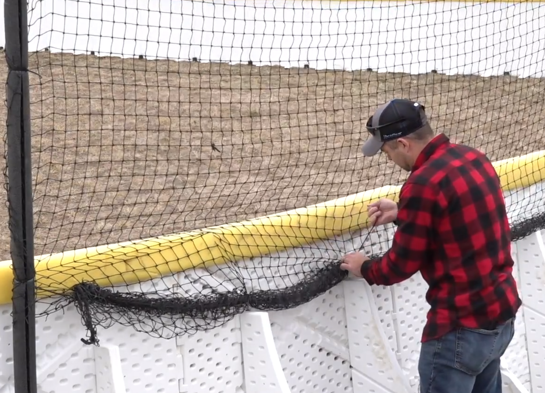 Rolling up netting and attaching zip tie to keep it off the ground