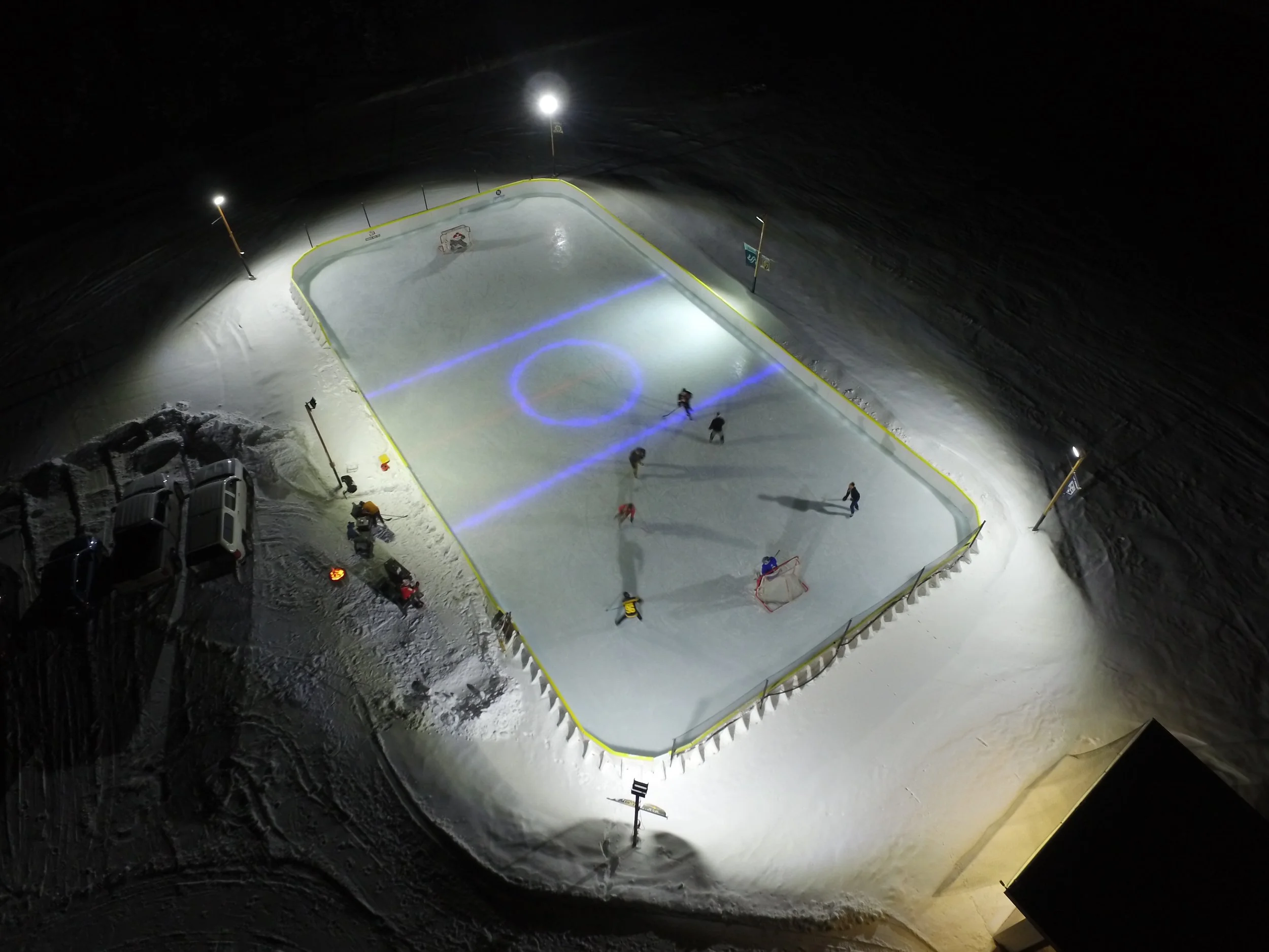 Playing hockey on outdoor ice rink, overhead drone view