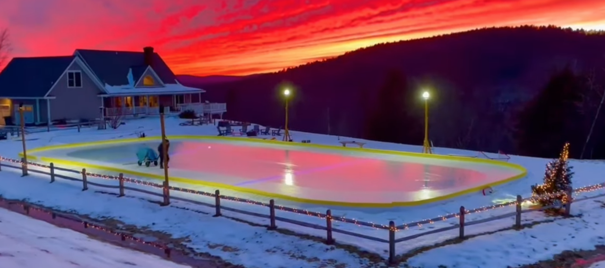A house with a ODR and a guy using a walk behind ice resurfacer. Beautiful sunset