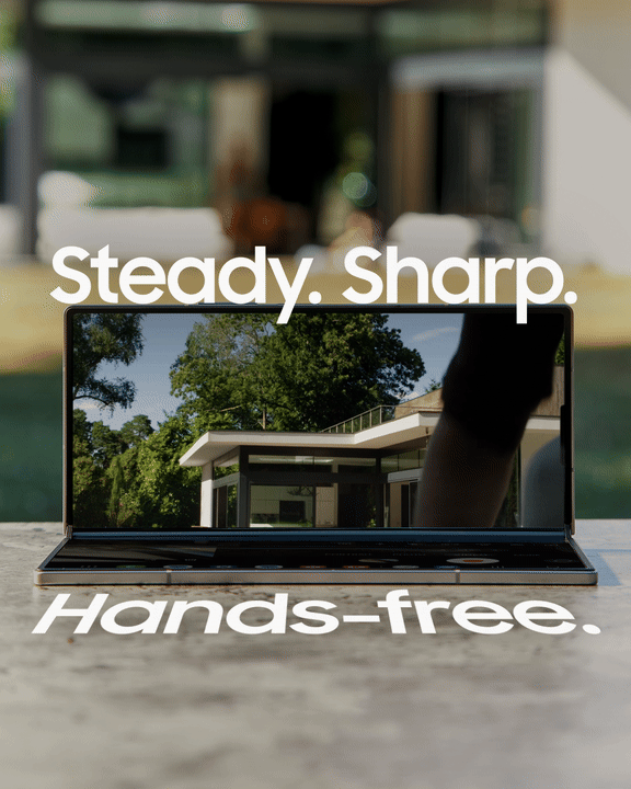 A laptop on a table displaying a house and trees on its screen with the text "Steady. Sharp. Hands-free." overlaid.