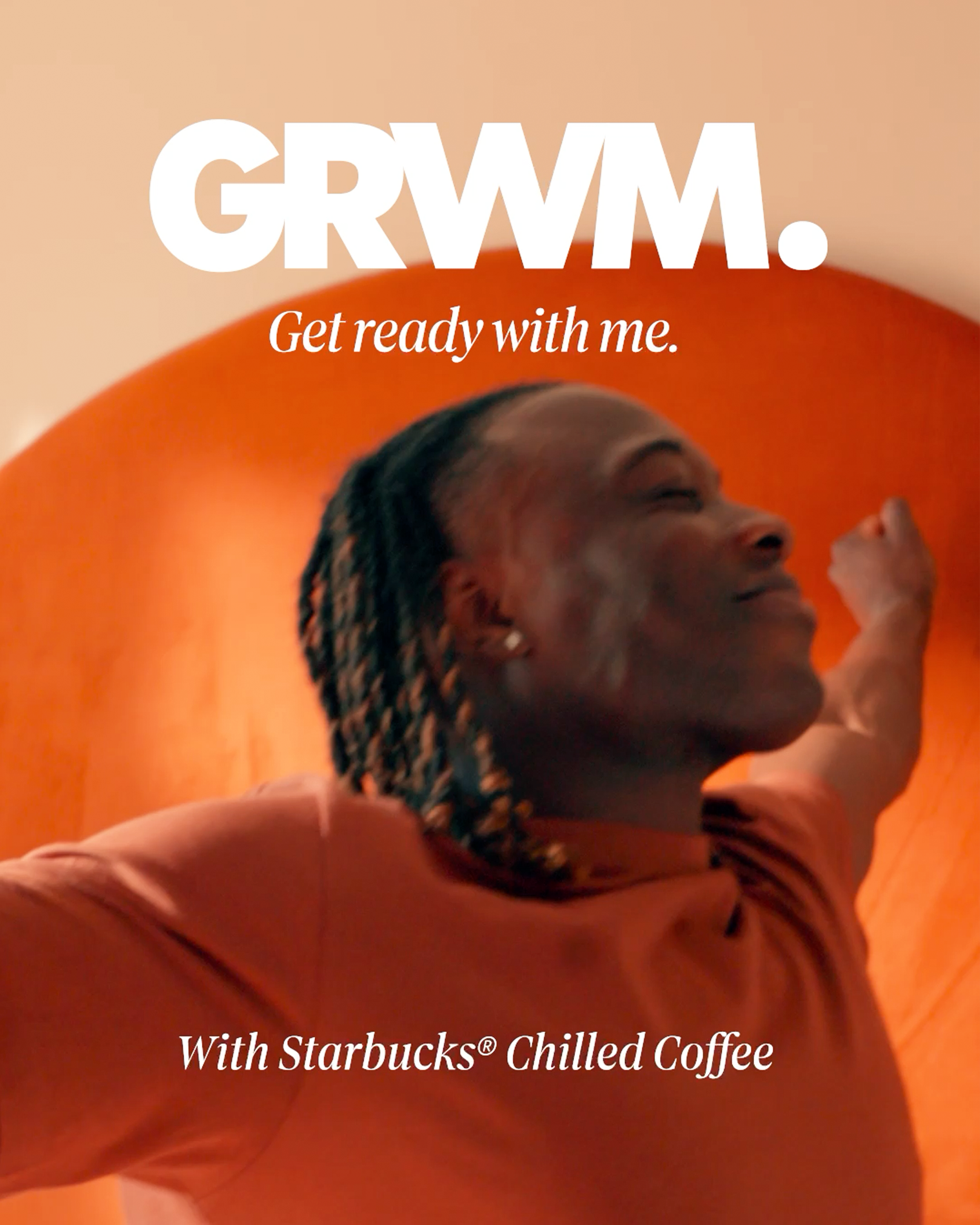 Person with braided hair smiling and stretching arms in front of an orange background, with promotional text for Starbucks cold coffee.