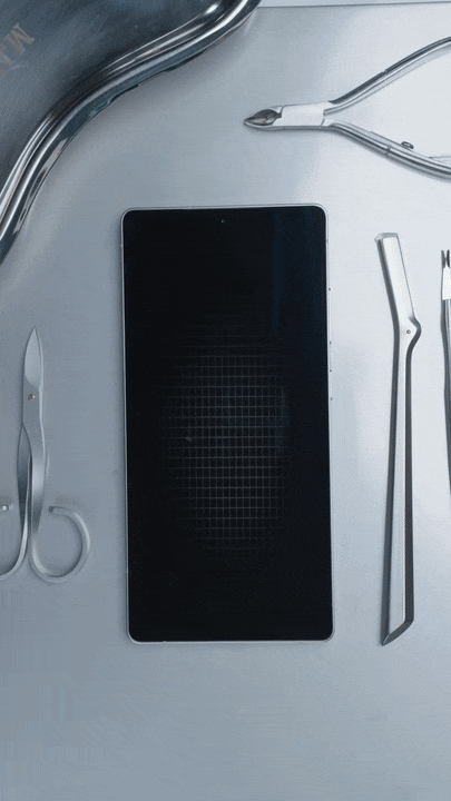 Medical tools and smartphone arranged on a metallic surface.