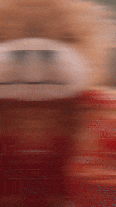 Blurred image of a person holding a red object.