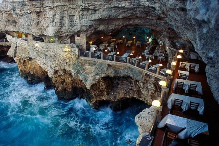 Restaurant situé dans une grotte au-dessus de la mer agitée.
