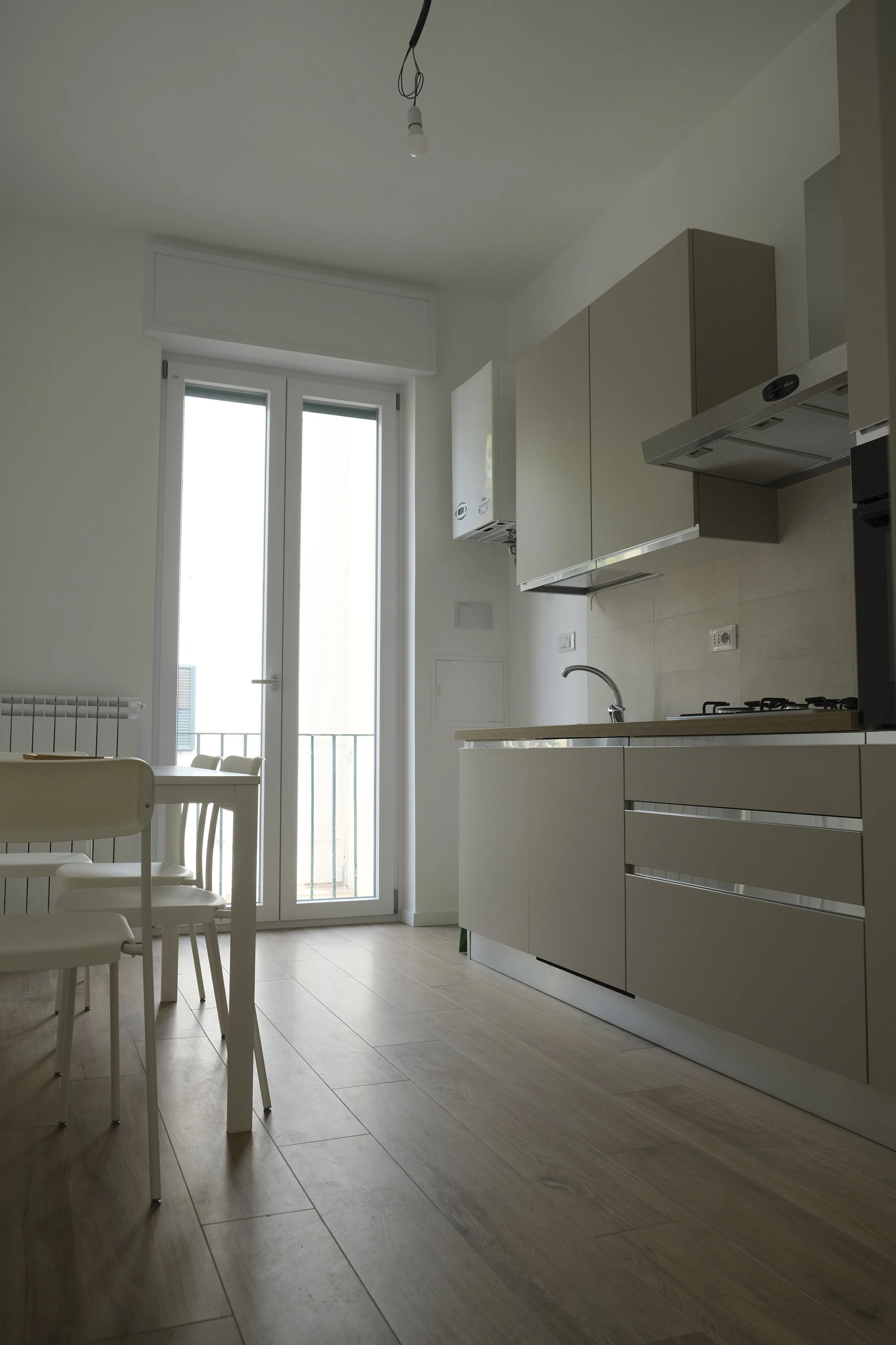 Cuisine moderne avec table et chaises près d'un balcon ensoleillé