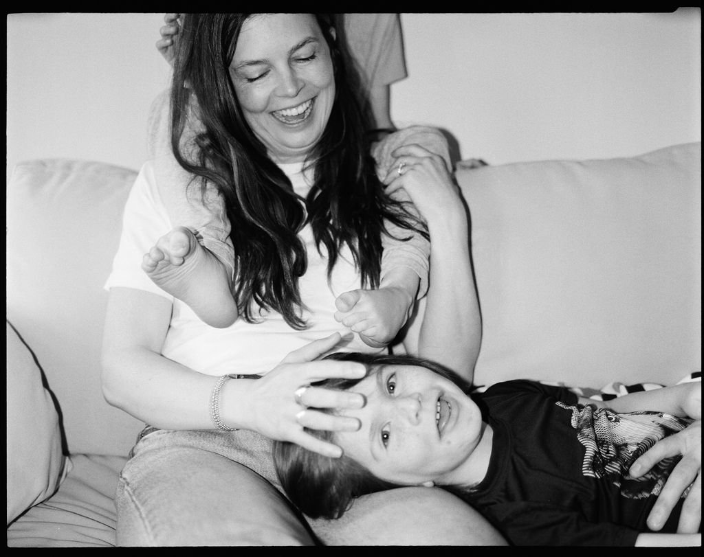 A woman and a child playing on a couch, smiling and having fun.