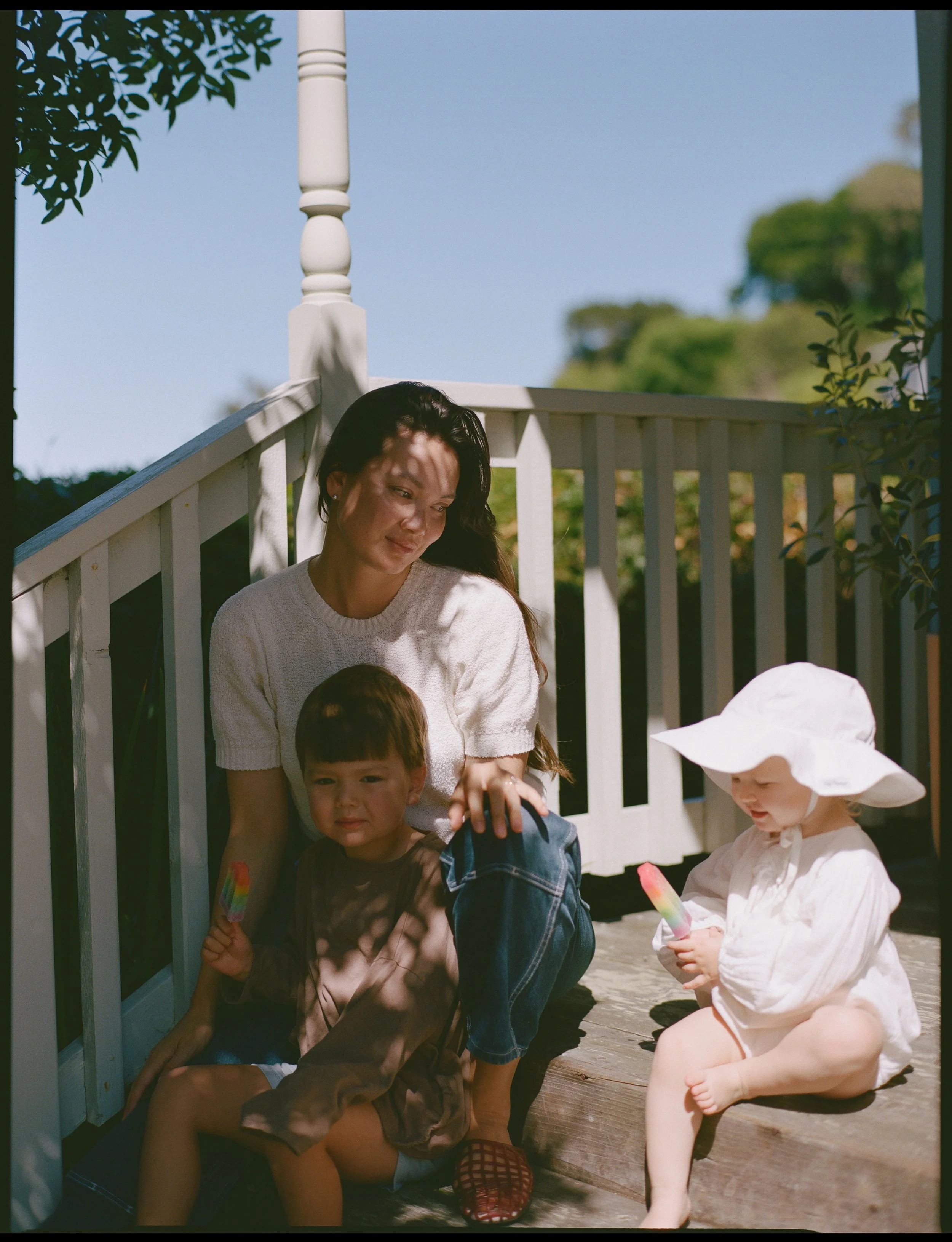a color medium format film image of a mother and her son and daughter sitting on their front porch in Sausalito, California 