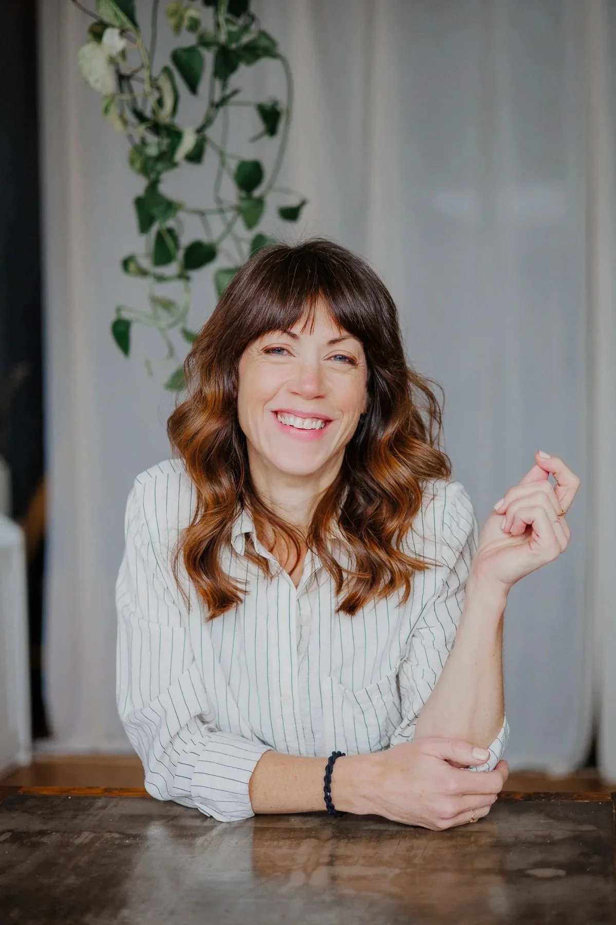 Woman sitting at table mid-laugh