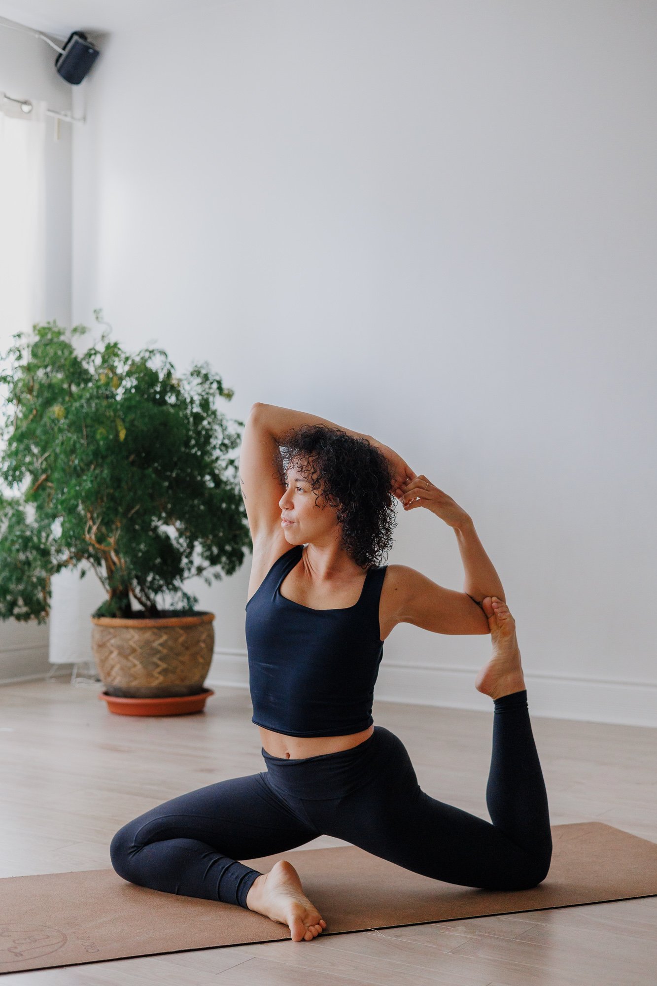 Yoga teacher doing king pigeon pose in a Montreal yoga studio