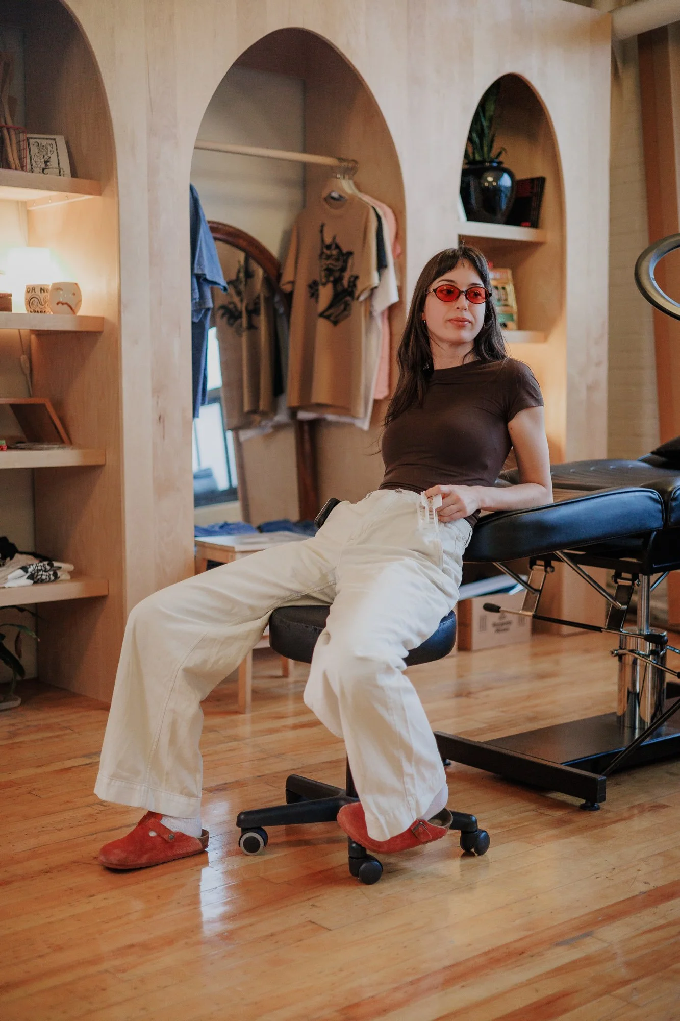 Girl or woman sitting casually in a tattoo studio
