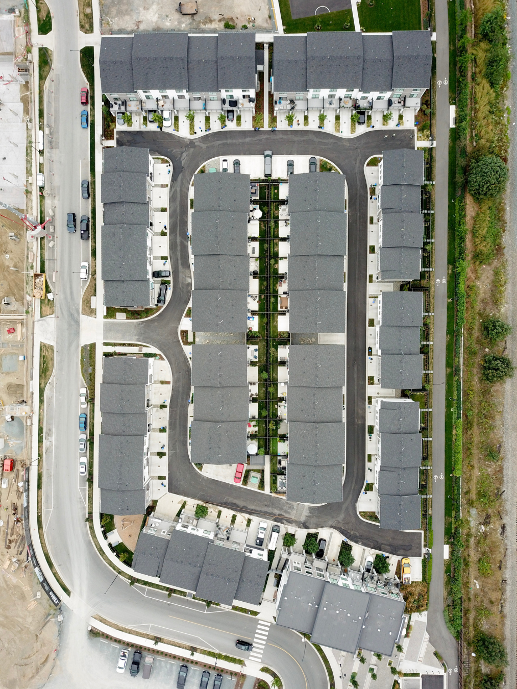 An aerial view of a residential apartment complex with multiple buildings, parking lots, and a central courtyard.