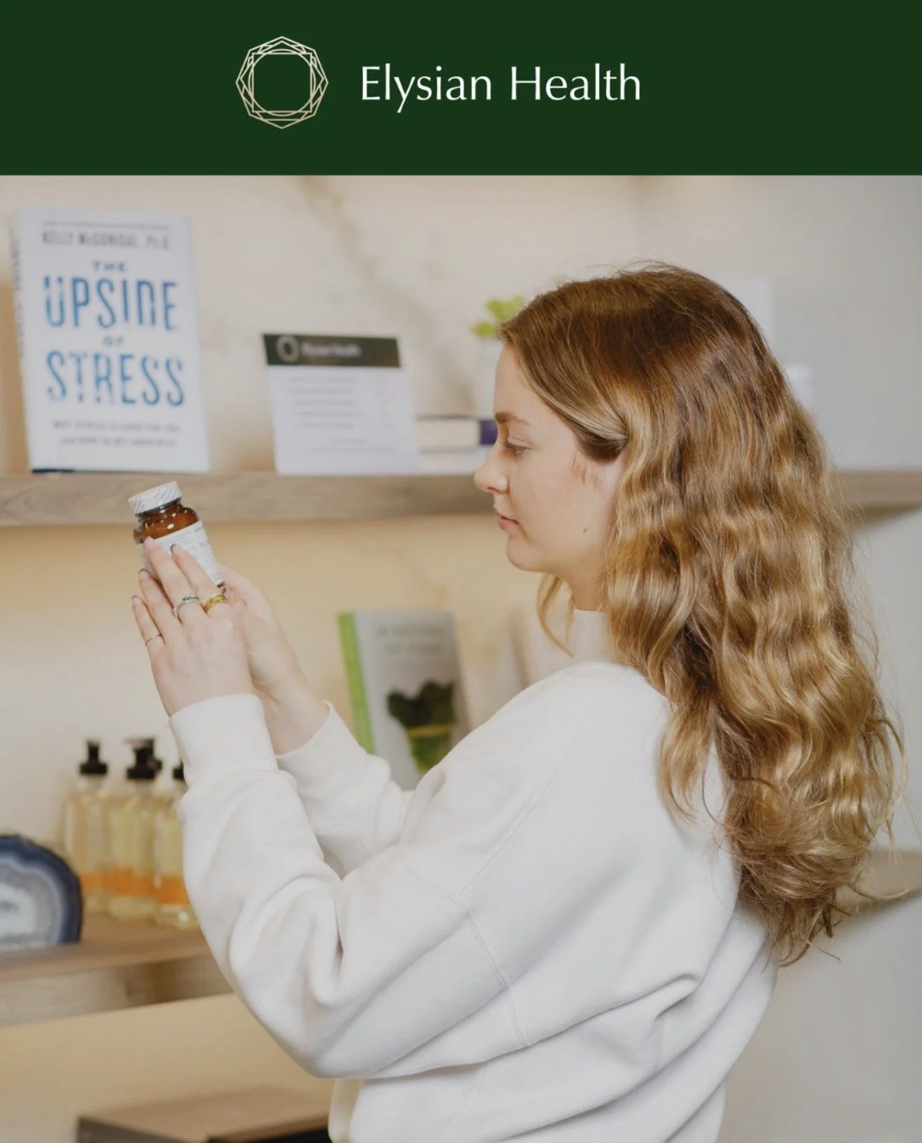 A woman with long, wavy red hair examines a bottle of medication in a health store, with health-related books and products on shelves behind her.