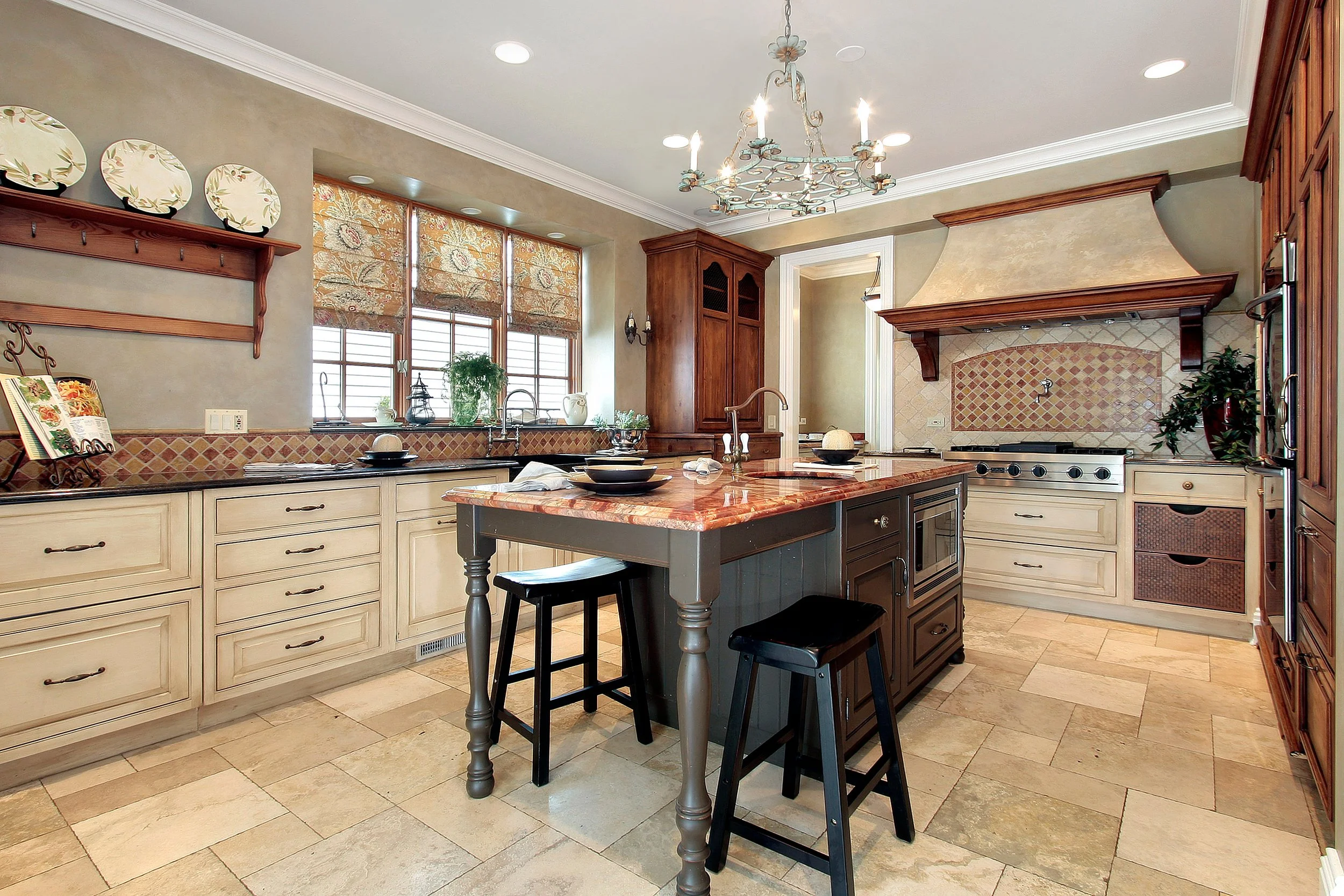 Kitchen with cream cabinets, a central island with a granite countertop, and a chandelier