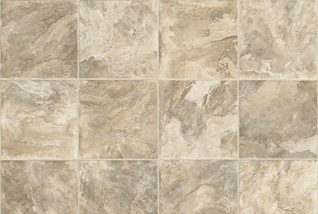 Close-up of beige and gray marbled ceramic tiles on a wall or floor.