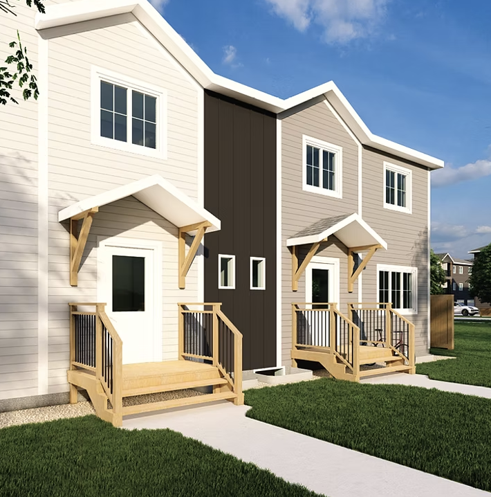 Two new developed modern multi-family townhouses with small wooden porches, green grass, concrete walkways, and a blue sky with clouds.